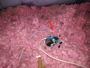 Open junction box inside an attic